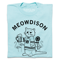 A folded pastel blue t-shirt with black ink. Curved text at the top says, "Meowdison" above an illustration of a cat holding a pint of beer while wearing a hockey jersey. There are lawn flamingos and a rocking chair in the background.