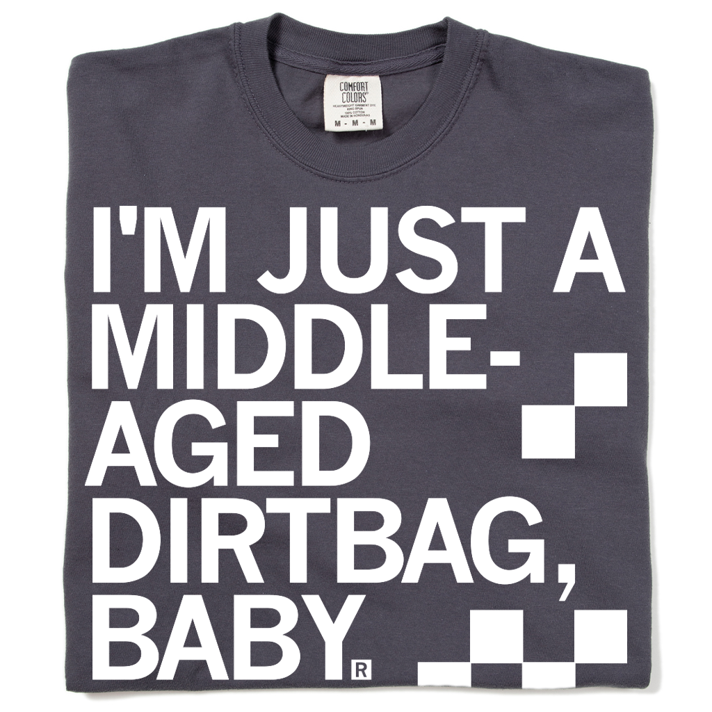 A folded dark grey t-shirt with left aligned white ink text that says, "I'm just a middle-aged dirtbag, baby."