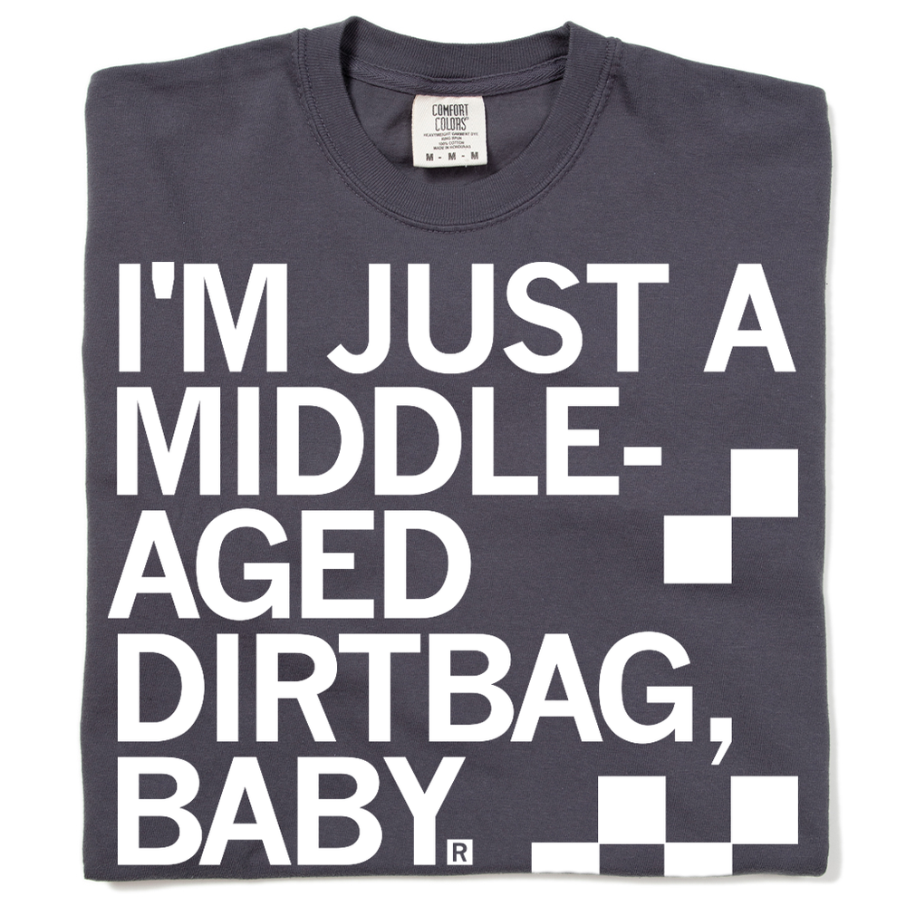 A folded dark grey t-shirt with left aligned white ink text that says, "I'm just a middle-aged dirtbag, baby."