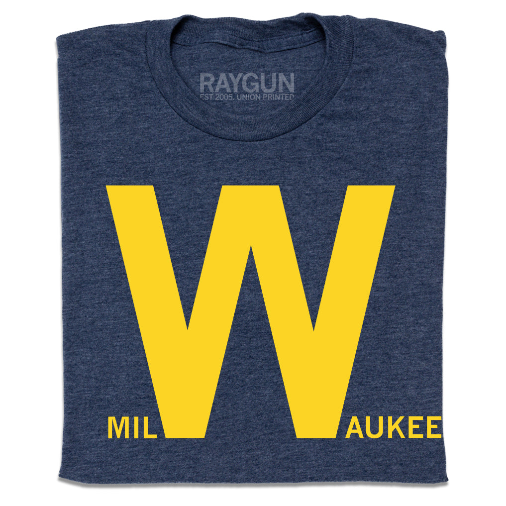 Folded heather navy t-shirt with yellow text that says, "milWaukee" with just the W in huge font.