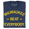 Folded heather navy t-shirt with bright yellow text that says, "Milwaukee Beat Everybody."