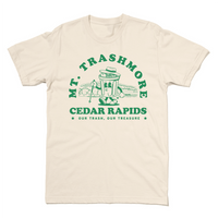 Natural colored t-shirt with green ink that reads "Mt. Trashmore, Cedar Rapids. Our trash, our treasure" framing an image of a cartoon trashcan going for a hike with Mt. Trashmore in the background.