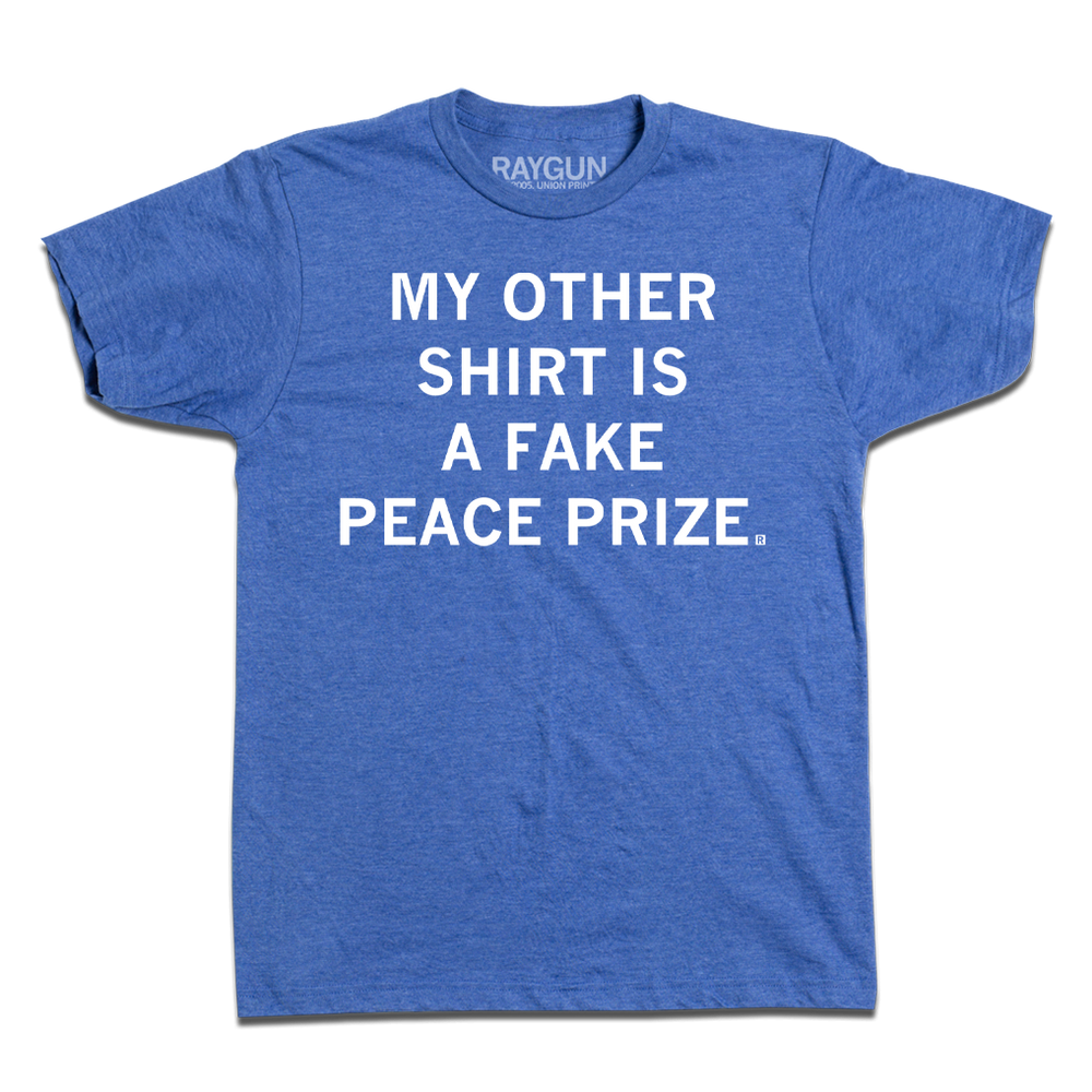 A heather blue tee with centered white ink print that reads "My Other Shirt is a Fake Peace Prize"