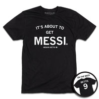 short sleeve black t-shirt with centered white ink print that reads "It's About to Get Messi" with smaller text below that says, "Mesaiya Bettis" beside a small outline of Iowa with the number 9 in it. A second picture in a small circle frame is in the bottom right corner, showing the back print. The back is laid out like a jersey with "Bettis" printed across the shoulders above the number 9.