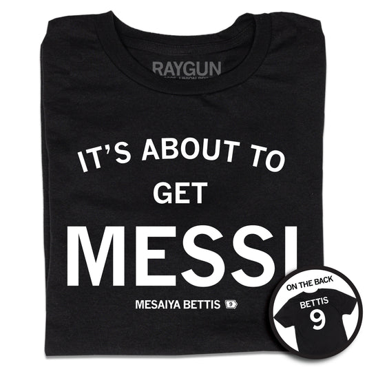 A folded short sleeve black t-shirt with centered white ink print that reads "It's About to Get Messi" with smaller text below that says, "Mesaiya Bettis" beside a small outline of Iowa with the number 9 in it. A second picture in a small circle frame is in the bottom right corner, showing the back print. The back is laid out like a jersey with "Bettis" printed across the shoulders above the number 9.