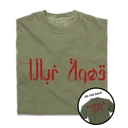 A folded heavyweight green shirt with red print. The front says, "Nabala Cafe" in Arabic. The back reads "Nabala Cafe. Uptown, Chicago" in English.