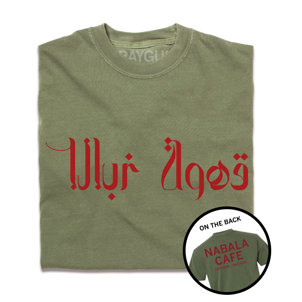 A folded heavyweight green shirt with red print. The front says, "Nabala Cafe" in Arabic. The back reads "Nabala Cafe. Uptown, Chicago" in English.