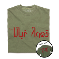 A folded heavyweight green shirt with red print. The front says, "Nabala Cafe" in Arabic. The back reads "Nabala Cafe. Uptown, Chicago" in English.