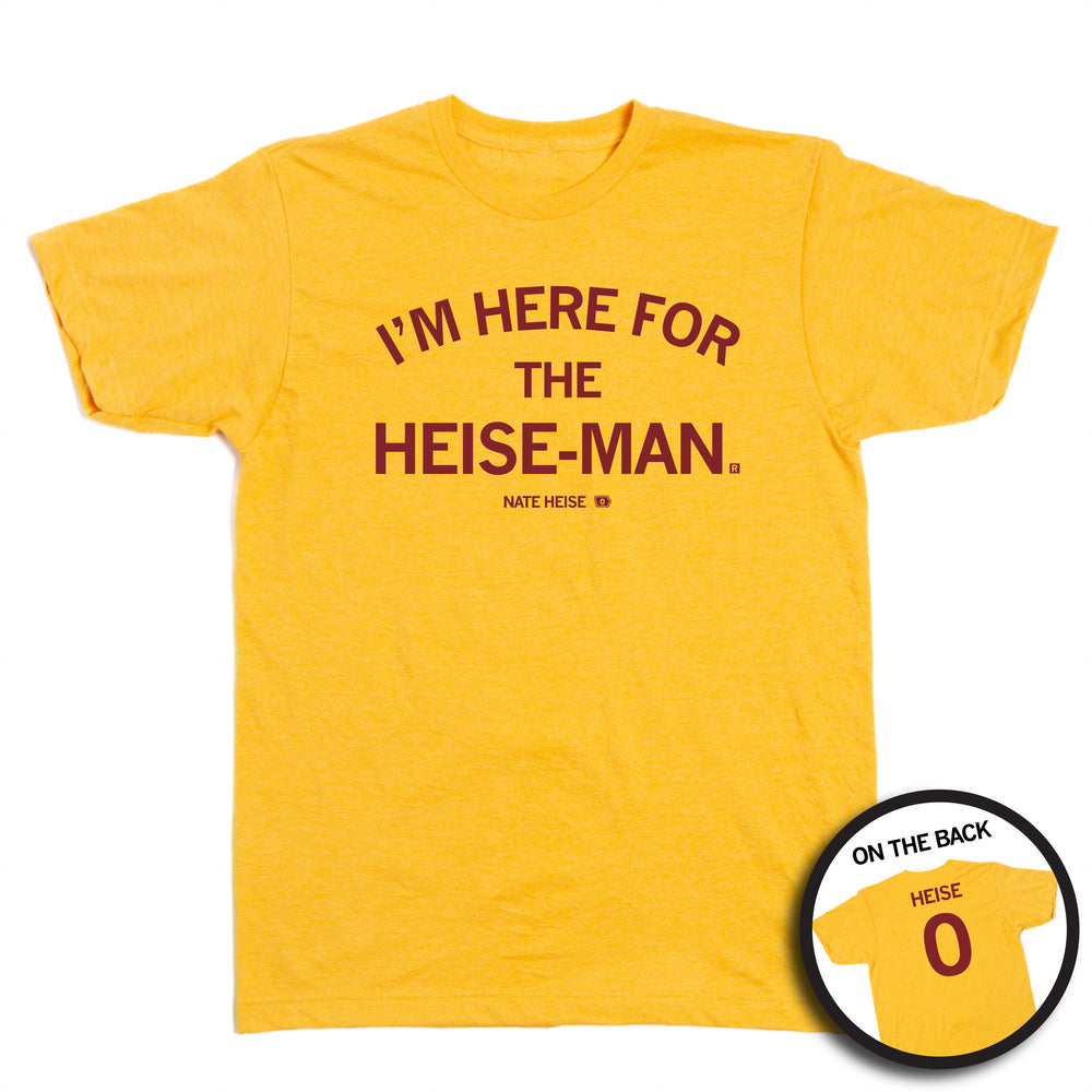A heather gold t-shirt with cardinal ink on the front and back. The front reads "I'm here for the heise-man" and the back is laid out like a jersey with "Heise" at the top and a 0 below.