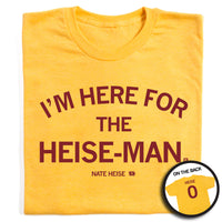 A folded heather yellow t-shirt with cardinal ink that reads "I'm here for the heise-man" over smaller text that says, "Nate Heise" and a small outline of Iowa with the number 0 in the center. The back of their says, "Heise" over the number 0, laid out like a jersey.
