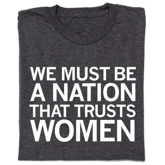 Dark gray RAYGUN t-shirt with the white text WE MUST BE A NATION THAT TRUSTS WOMEN.
