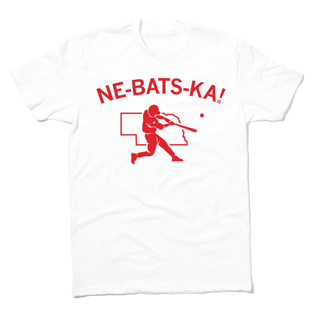 White Raygun t-shirt with a red graphic of a baseball player swinging at a ball in front of the outline of Nebraska and the text NE-BATS-KA!.