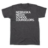 Dark gray RAYGUN t-shirt featuring the text NEBRASKA NEEDS SCHOOL COUNSELORS in white lettering on the chest.