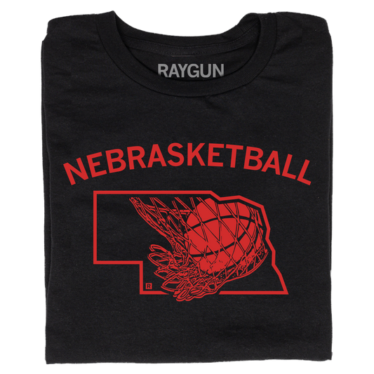 A folded black t-shirt with brite red ink and curved text that says, "Nebrasketball" above an outline of Nebraska with a basketball going through a hoop.