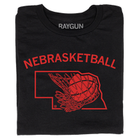 A folded black t-shirt with brite red ink and curved text that says, "Nebrasketball" above an outline of Nebraska with a basketball going through a hoop.