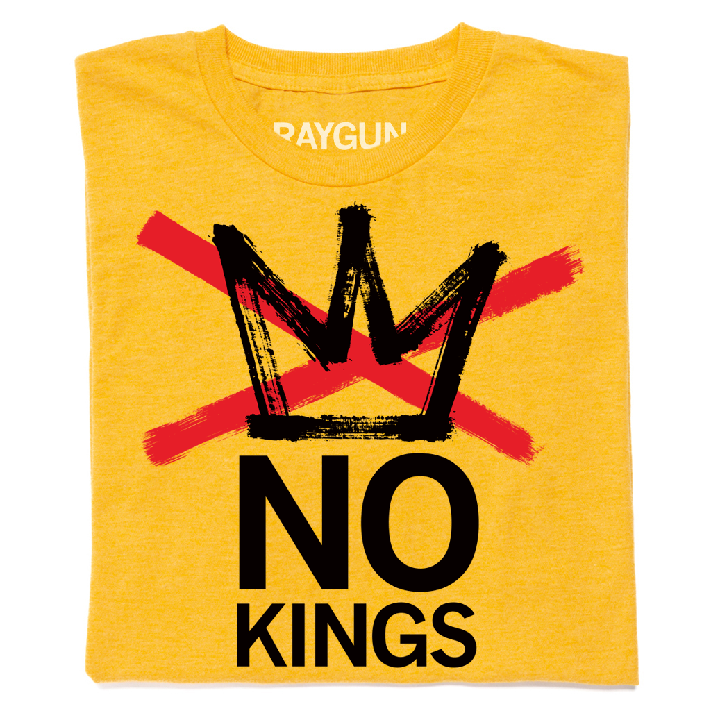 A folded heather gold t-shirt with a black crown and "No Kings" printed below. A red in X is printed across the crown.