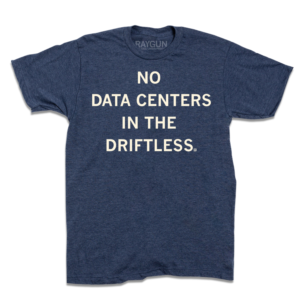 A short-sleeve heather denim t-shirt with centered cream ink that reads "No Data Centers In The Driftless"