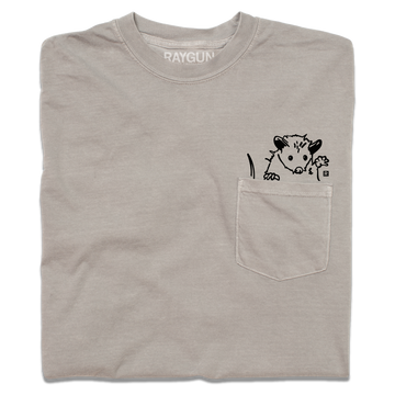 Taupe heavyweight cotton pocket t-shirt featuring a black line-drawing of an opossum peeking out of the pocket.