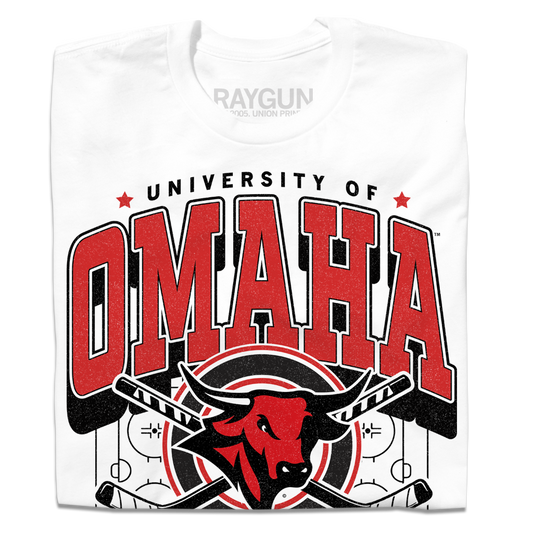 White shirt with red and black ink that says, "University of Omaha Hockey. Home of the Mavericks" with the university's bull mascot logo over a pair of crossing hockey sticks and an ice rink.