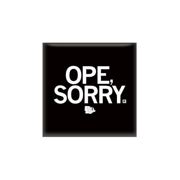 A square black magnet with all caps white text that says, 