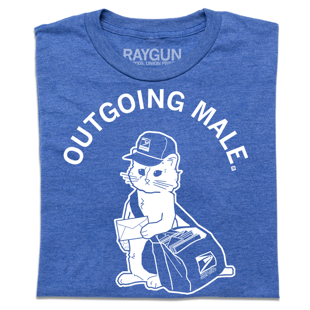A folded heather blue short sleeve t-shirt with curved white text near the top that says, "OUTGOING MALE" above an illustration of a cat dressed as a mail carrier with a mail back over his shoulder and a letter in hand.