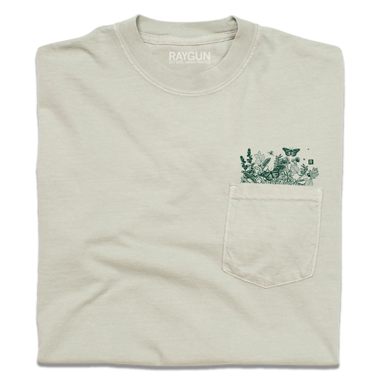 Light beige, garment-dyed heavyweight t-shirt with a chest pocket featuring a green line-art print of wildflowers and a butterfly.