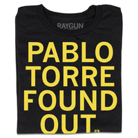 Folded black t-shirt with all caps yellow text that says, "Pablo Torre found out."