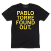 A short-sleeve black tee with centered yellow ink text that reads "PABLO TORRE FOUND OUT."