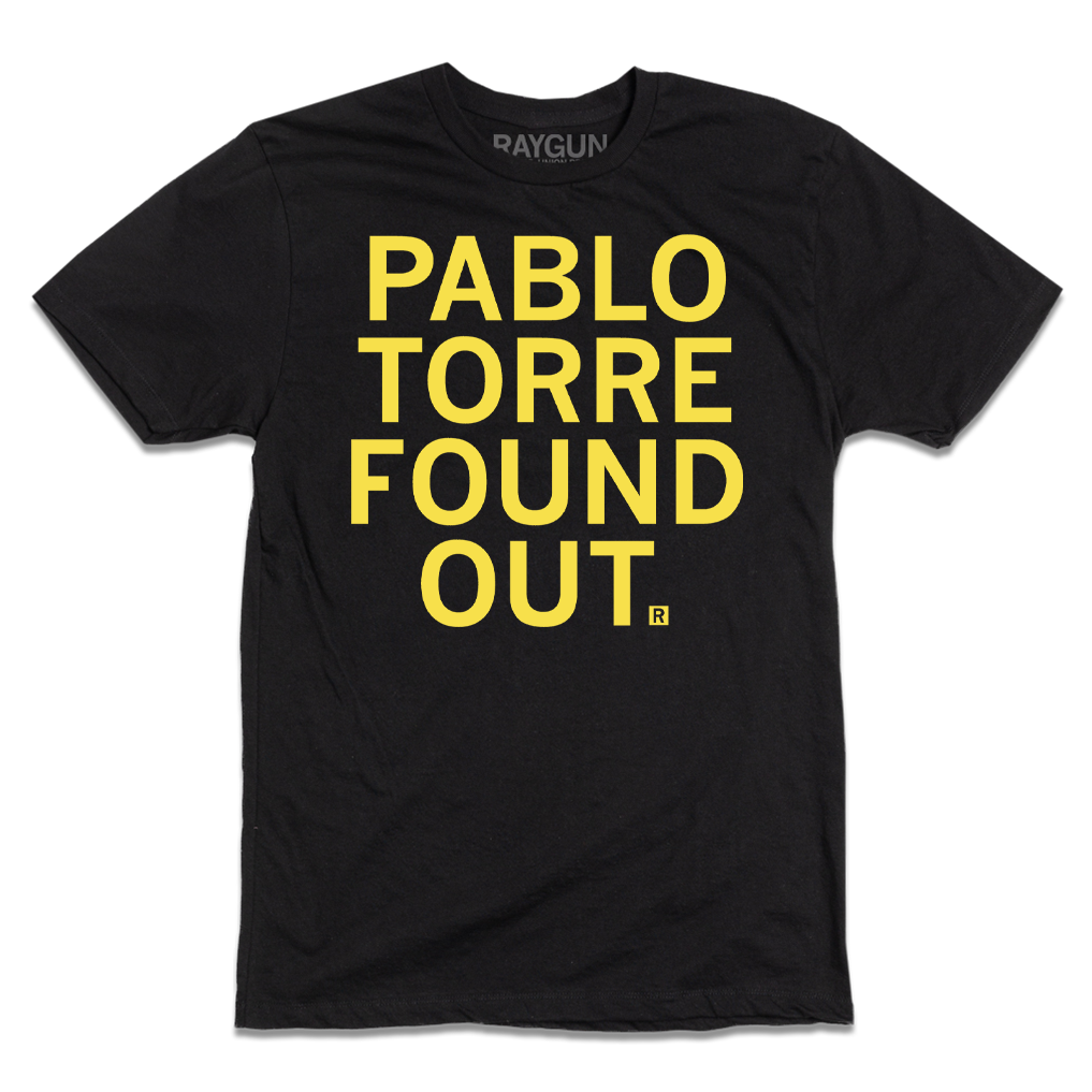 A short-sleeve black tee with centered yellow ink text that reads "PABLO TORRE FOUND OUT."