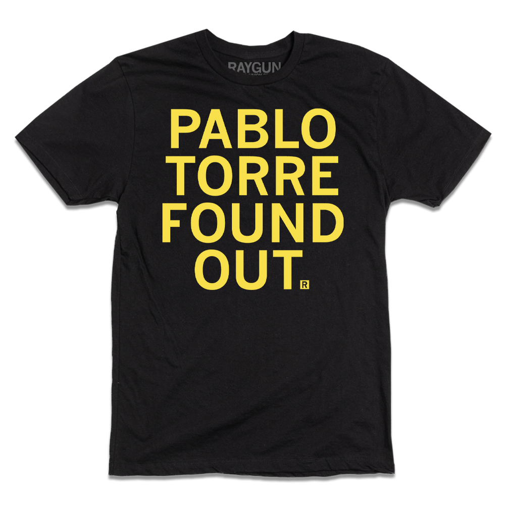 A short-sleeve black tee with centered yellow ink text that reads "PABLO TORRE FOUND OUT."