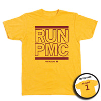 A short sleeve heather yellow t-shirt with cardinal ink print that says, "RUN PMC" in large, outlined text with a thick red line printed above and below. Smaller print at the bottom reads "PAM McCune" beside a tiny Iowa with the number 1 in it. A small picture in a circle frame in the bottom right shows the back of the shirt. The back of the shirt is printed like a jersey with "McCune" across the shoulders above a large number 1.