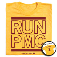 Folded heather yellow t-shirt with cardinal ink print that says, "RUN PMC" in large, outlined text with a thick red line printed above and below. Smaller print at the bottom reads "PAM McCune" beside a tiny Iowa with the number 1 in it. The back of the shirt is printed like a jersey with "McCune" across the shoulders above a large number 1.