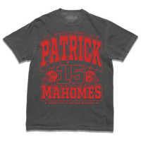 Dark grey shirt with bright red ink that reads "Saint Patrick of Kansas City. Patrick Mahomes #15. There's No Place Like Mahomes" over an illustration of a football field with a football helmet to either side.