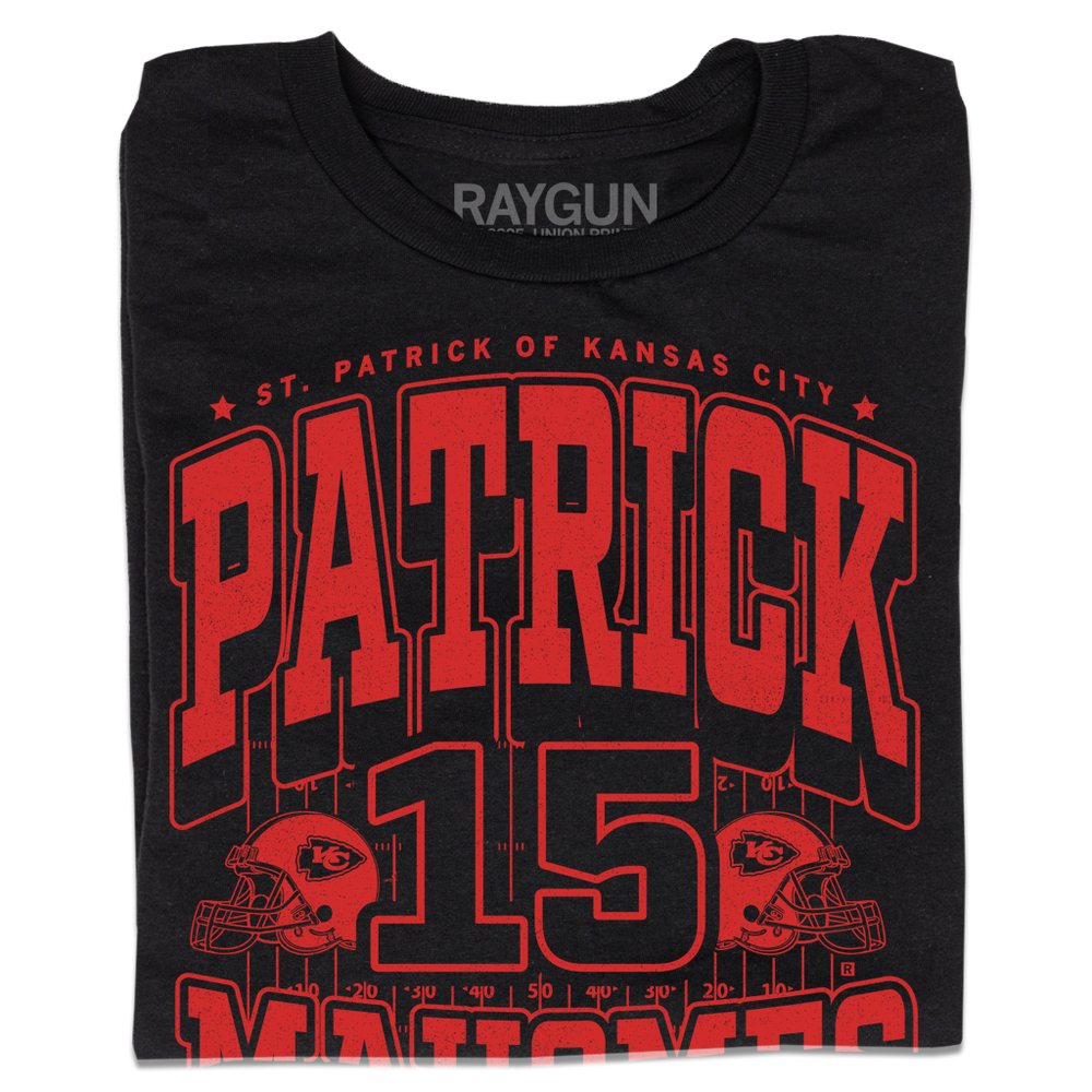 A folded black shirt with bright red ink that reads "Saint Patrick of Kansas City. Patrick Mahomes #15. There's No Place Like Mahomes" over an illustration of a football field with a football helmet to either side.