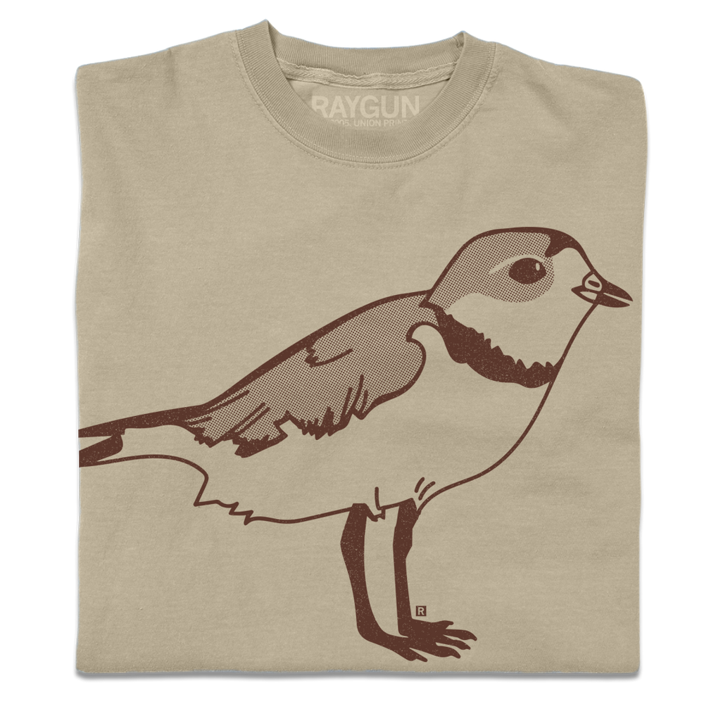 A folded khaki crewneck t-shirt with a brown ink illustration of a plover.