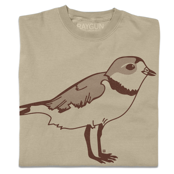 A folded khaki crewneck t-shirt with a brown ink illustration of a plover.