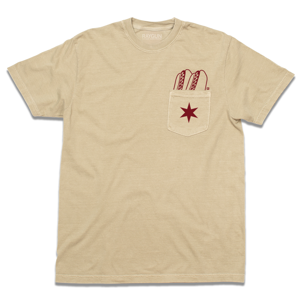 A beige pocket tee with dark red print of two hotdogs above the pocket and a Chicago flag star on the pocket.