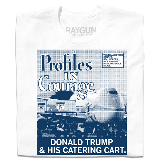 Folded white shirt with a picture printed as a gradient with navy ink. The image is of a plane landed at an airport loading Donald Trump hiding in a food cart into the plane. A white square with a blue outline and blue text in the top right reads "WHEN FACED WITH DANGER, REAL HEROES HIDE AMONGST MICROWAVEABLE MEALS." Large text in the top left says, "Profiles In Courage" and smaller white font at the bottom of the print reads "DONALD TRUMP & HIS CATERING CART."
