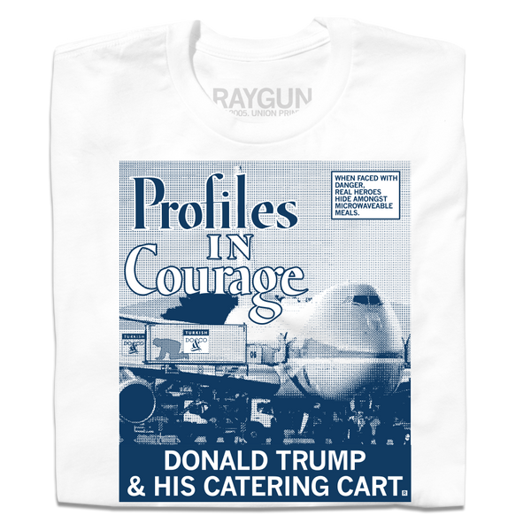 Folded white shirt with a picture printed as a gradient with navy ink. The image is of a plane landed at an airport loading Donald Trump hiding in a food cart into the plane. A white square with a blue outline and blue text in the top right reads 