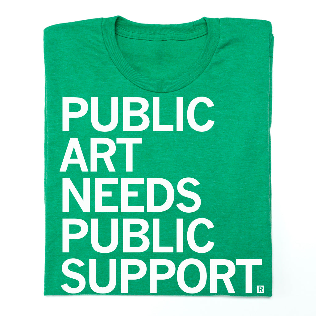 A union made green t-shirt with the white text PUBLIC ART NEEDS PUBLIC SUPPORT.