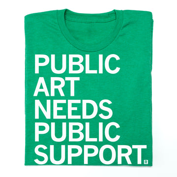 A union made green t-shirt with the white text PUBLIC ART NEEDS PUBLIC SUPPORT.