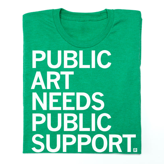 A union made green t-shirt with the white text PUBLIC ART NEEDS PUBLIC SUPPORT.