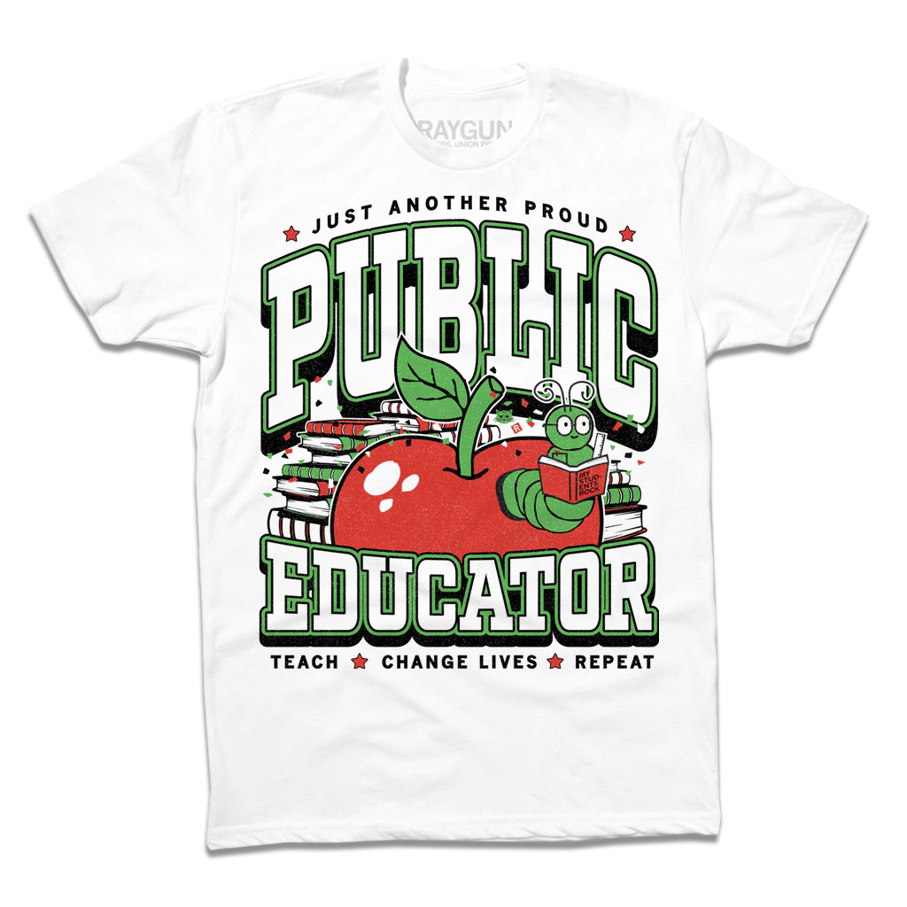 A white tee with text in black, green, and white that reads "Just another proud public educator. Teach, change lives, repeat" around a red apply with a bookworm popping out and a stack of red & green books in the back.