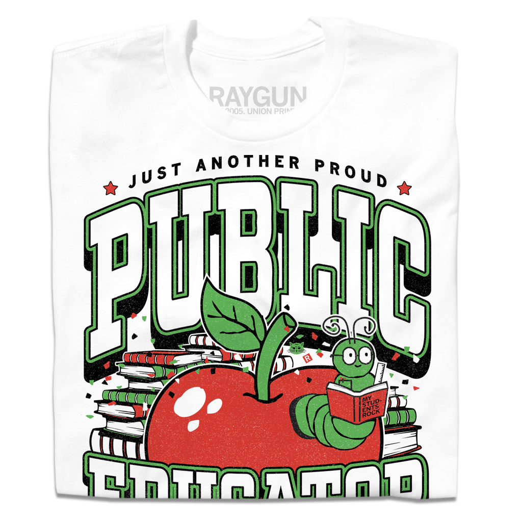 White t-shirt with text in black, green, and white that reads "Just another proud public educator. Teach, change lives, repeat" around a red apply with a bookworm popping out and a stack of red & green books in the back.
