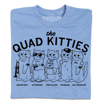 Light heather blue shirt with black ink that reads "The Quad Kitties: Davenpurrt, Kittendorf, Pawk Island, Meowline, East Meowline" with illustrations of five differently dressed cats in a line.