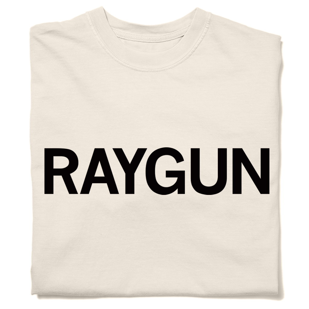 A folded cream heavyweight t-shirt with "RAYGUN" printed in black ink.