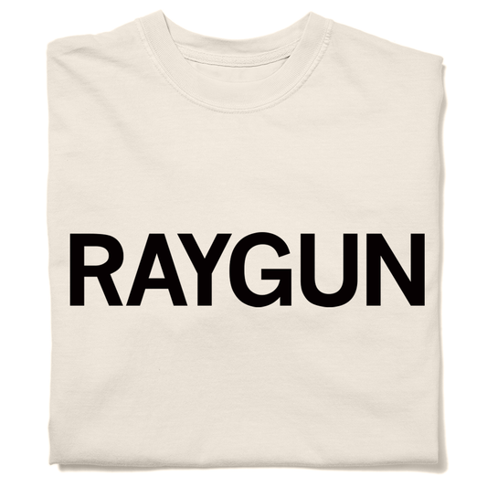 A folded cream heavyweight t-shirt with "RAYGUN" printed in black ink.