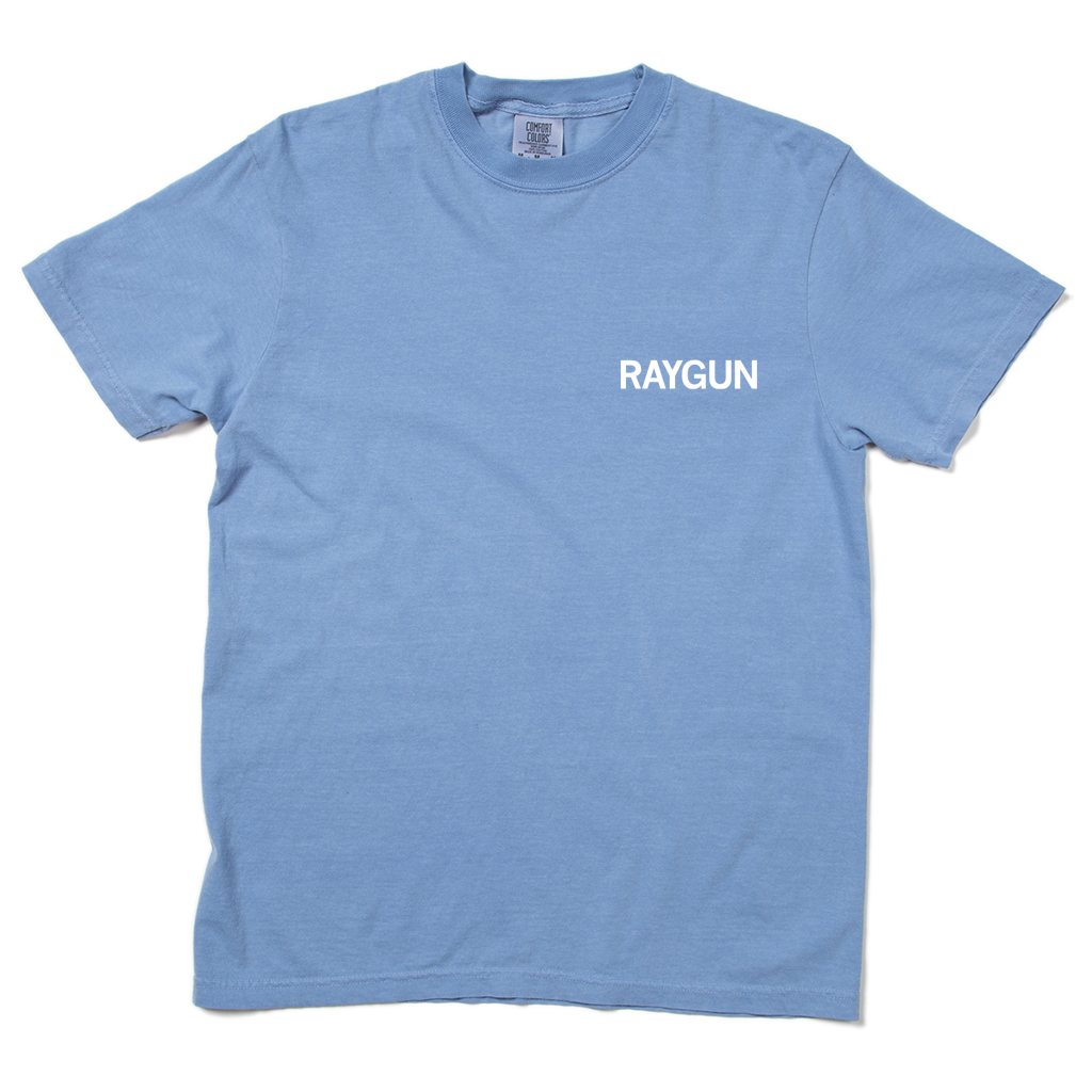 Comfort Colors washed denim blue t-shirt with white print across the left side of the chest that says, "RAYGUN."