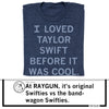A folded heather denim RAYGUN t-shirt printed with the text, I LOVED TAYLOR SWIFT BEFORE IT WAS COOL.