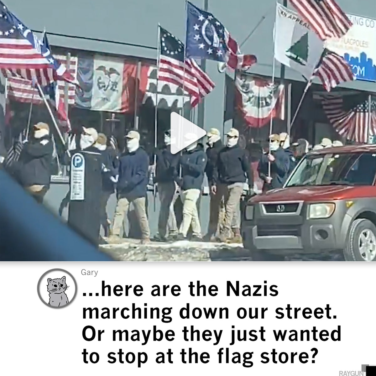 A group of people wearing face masks and dark jackets march down a street carrying historical and American flags, one wearing a Des Moines t-shirt, as a red SUV remains parked nearby.